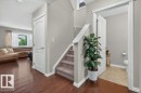 Hardwood-finish flooring extending into the main living area, complemented by a carpeted staircase with white risers and handrail - 692 Secord Boulevard Nw, Edmonton, AB  - Indoor Photo Showing Other Room 