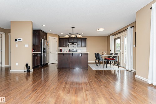 Open-concept kitchen and dining area featuring rich wood-finish flooring - 2605 Anderson Crescent Sw, Edmonton, AB - Indoor