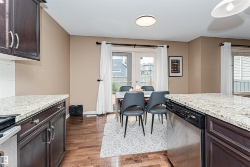 Kitchen area featuring dark wood-finish cabinetry and light-toned, speckled countertops - 2605 Anderson Crescent Sw, Edmonton, AB - Indoor Photo Showing Kitchen
