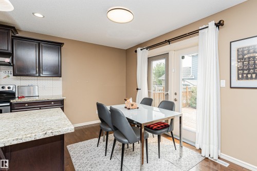 Dining area featuring wood-finish flooring and direct patio access through double glass doors - 2605 Anderson Crescent Sw, Edmonton, AB - Indoor