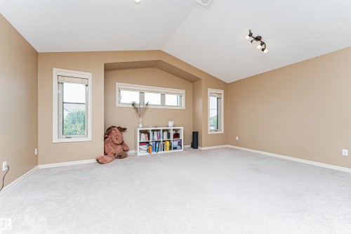 Expansive room featuring vaulted ceilings, light-colored carpeting, and multiple windows for abundant natural light - 2605 Anderson Crescent Sw, Edmonton, AB - Indoor Photo Showing Other Room