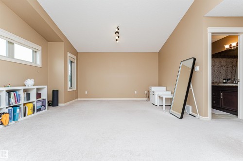 Spacious room featuring neutral carpeting and tan wall paint - 2605 Anderson Crescent Sw, Edmonton, AB - Indoor