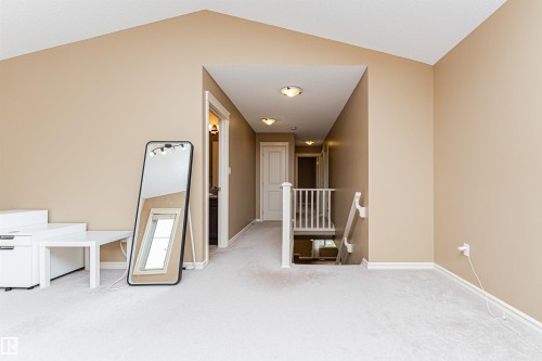 Spacious carpeted landing featuring vaulted ceilings and a hallway entry - 2605 Anderson Crescent Sw, Edmonton, AB - Indoor Photo Showing Other Room