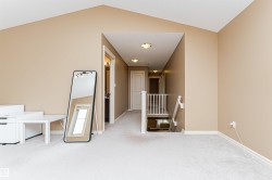 Spacious carpeted landing featuring vaulted ceilings and a hallway entry - 