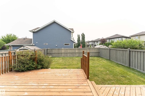 Spacious backyard featuring a multi-level wood deck with railing, a manicured lawn, and perimeter wood fencing - 2605 Anderson Crescent Sw, Edmonton, AB - Outdoor With Deck Patio Veranda With Exterior