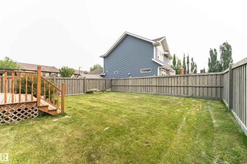 Expansive backyard featuring a manicured lawn, a wooden deck with railing, and a privacy fence - 2605 Anderson Crescent Sw, Edmonton, AB - Outdoor