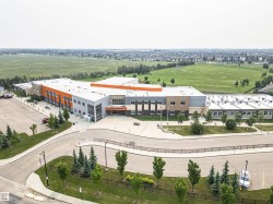 Modern institutional building with multi-toned facade, featuring orange, grey, and brown accents - 
