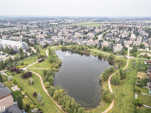Aerial perspective of a developed residential area featuring a central pond with a fountain - 2605 Anderson Crescent Sw, Edmonton, AB - Outdoor With Body Of Water With View