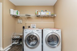 Dedicated laundry area featuring wire shelving and neutral wall tones - 