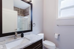 Bathroom vanity with a rectangular undermount sink, stone countertop, and dark wood-finish cabinetry - 