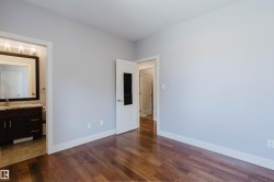 Wood-finish flooring throughout, complemented by light gray walls and white trim - 