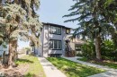 Gray stucco exterior featuring dark trim, multiple windows, and a prominent front entrance with dark railings - 10626 81 Avenue Nw, Edmonton, AB  - Outdoor With Facade 