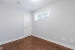 Room featuring wood-finish flooring, white baseboards, and light gray walls - 
