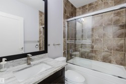 Bathroom featuring a spacious vanity with a white countertop, an undermount sink, and a dark wood-finish cabinet - 