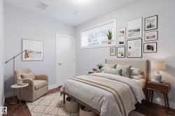 Interior room featuring wood-finish flooring, a white trim door, and a horizontal window with blinds - 