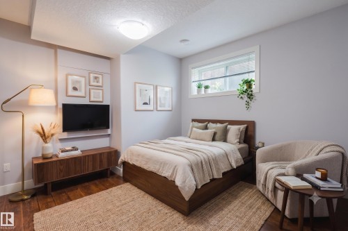 Hardwood-style flooring throughout this room features a built-in window with horizontal blinds - 10626 81 Avenue Nw, Edmonton, AB - Indoor Photo Showing Bedroom