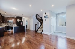 Spacious open-concept living area featuring wood-finish flooring - 
