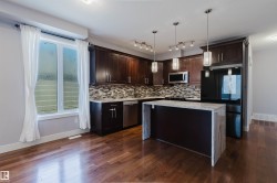 Kitchen featuring rich wood cabinetry, stainless steel appliances, and a mosaic tile backsplash - 