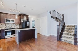 Open-concept living area featuring rich wood-finish flooring - 