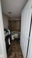 Bathroom featuring dark wood-finish vanity with countertop, white toilet, and tile flooring - 