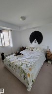 Carpeted room featuring a window with blinds, white walls, and a ceiling-mounted light fixture - 