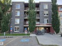 Multi-story building featuring a stone veneer facade, balconies with metal railings, and a prominent entrance with an overhead awning - #415 12045 22 Av Sw, Edmonton, AB  - Outdoor With Balcony With Facade 