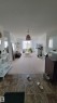 Open-concept living space featuring a pendant light fixture, light-toned walls, and a large window with sheer curtains - #415 12045 22 Av Sw, Edmonton, AB  - Indoor 