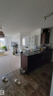 Kitchen area featuring dark cabinetry, a black countertop, and a double-basin stainless steel sink - 