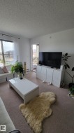 Living area featuring neutral-toned carpet flooring and white painted walls - 