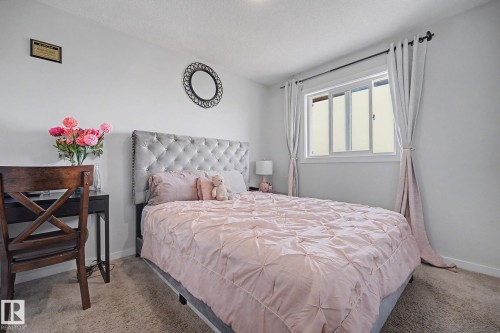 Carpeted bedroom with a window featuring white trim and drapes - 22419 80 Avenue Nw, Edmonton, AB - Indoor Photo Showing Bedroom