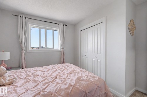 Room featuring a large window with white trim, light-colored walls, and a bi-fold closet door - 22419 80 Avenue Nw, Edmonton, AB - Indoor Photo Showing Bedroom