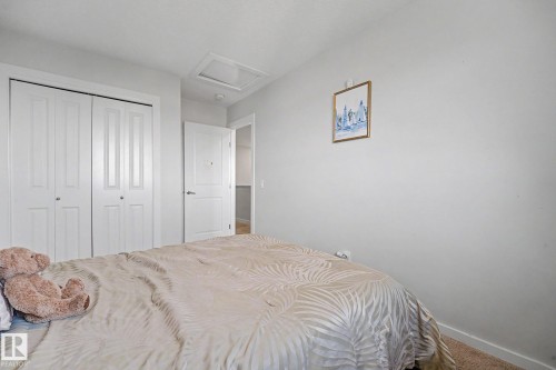 White walls and carpeted flooring define this room, featuring bi-fold closet doors, a white interior door, and a ceiling-mounted light fixture - 22419 80 Avenue Nw, Edmonton, AB - Indoor Photo Showing Bedroom