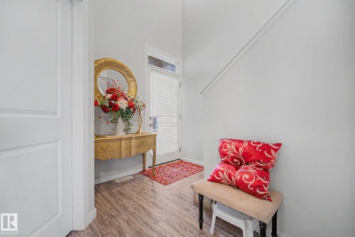 Entryway with wood-finish flooring, white paneled door, and a partially visible staircase - 22419 80 Avenue Nw, Edmonton, AB -  Photo Showing Other Room