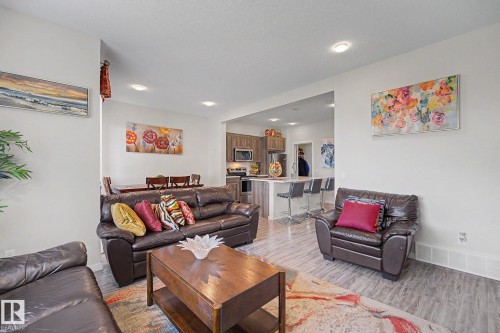 Open-concept living area featuring wood-finish flooring, recessed lighting, and a kitchen with stainless steel appliances and a breakfast bar - 22419 80 Avenue Nw, Edmonton, AB - Indoor Photo Showing Living Room