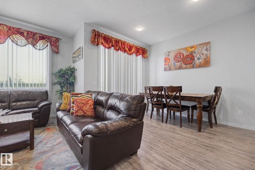 Open-concept living and dining area featuring wood-finish flooring, recessed lighting, and vertical window blinds - 22419 80 Avenue Nw, Edmonton, AB - Indoor Photo Showing Living Room