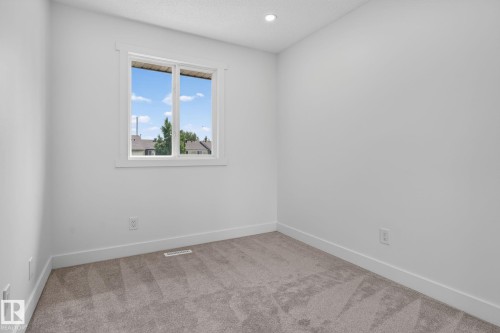 Bright room featuring light gray carpet, white walls, a white-framed window, and a recessed ceiling light - 8059 178 Street Nw, Edmonton, AB - Indoor Photo Showing Other Room