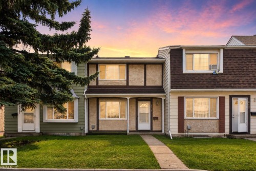 Exterior featuring a concrete walkway, green lawn, two-story structure, and multiple windows - 8059 178 Street Nw, Edmonton, AB - Outdoor With Facade