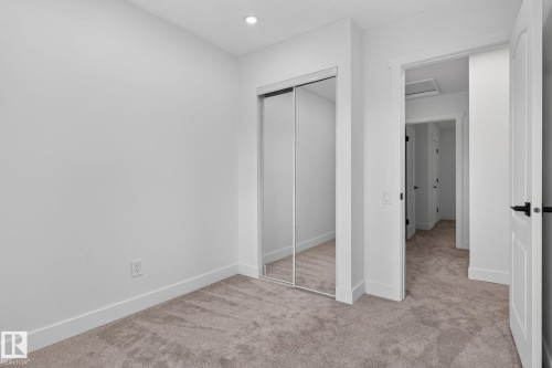 Interior room with light gray carpeting, white baseboards, and bright white walls - 8059 178 Street Nw, Edmonton, AB - Indoor Photo Showing Other Room