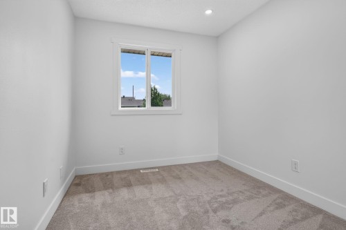 Neutral-toned wall-to-wall carpeting, white baseboards, and a white framed window - 8059 178 Street Nw, Edmonton, AB - Indoor Photo Showing Other Room