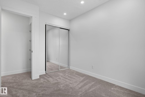 Bedroom featuring grey carpet flooring, recessed lighting, white walls, and a mirrored sliding closet door - 8059 178 Street Nw, Edmonton, AB - Indoor Photo Showing Other Room