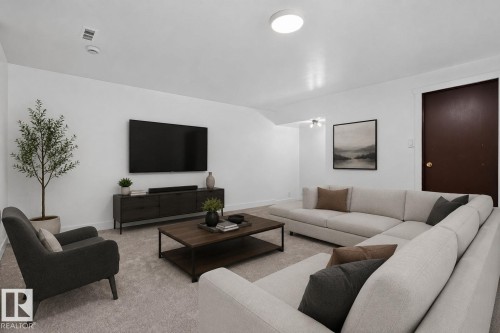 Expansive living area featuring light-toned carpeting and a ceiling-mounted light fixture - 8059 178 Street Nw, Edmonton, AB - Indoor Photo Showing Living Room