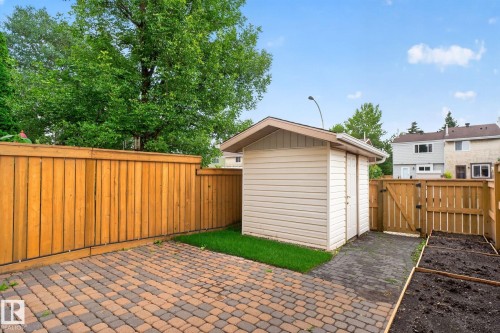 Private backyard featuring a paver patio, wood fencing, a storage shed, and a raised garden bed - 8059 178 Street Nw, Edmonton, AB - Outdoor With Exterior