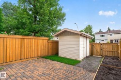 Private backyard featuring a paver patio, wood fencing, a storage shed, and a raised garden bed - 