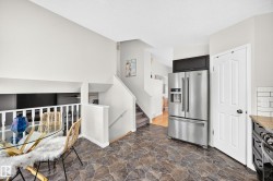 Kitchen area featuring irregular stone-look flooring, a stainless steel French door refrigerator, and a dark base cabinet - 