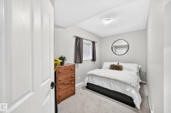 Bedroom featuring light gray wall paint, carpeting, a window with dark drapes, and a flush-mount ceiling light - 