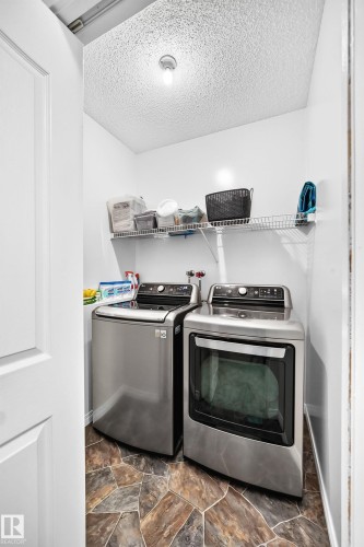 Dedicated laundry area with stone-look flooring, white walls, and a convenient wire shelf system - 3729 131A Avenue Nw, Edmonton, AB - Indoor Photo Showing Laundry Room