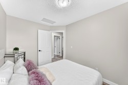 Interior room featuring light gray wall paint, white trim, wood-finish flooring, and white paneled doors with black hardware - 