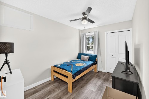 Room featuring wood-finish flooring, a double-door closet with bi-fold doors, and a ceiling fan with integrated lighting - 3729 131A Avenue Nw, Edmonton, AB - Indoor Photo Showing Bedroom