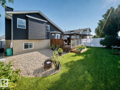 Rear exterior featuring dark horizontal siding and a stucco foundation - 3729 131A Avenue Nw, Edmonton, AB - Outdoor