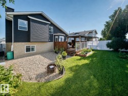 Rear exterior featuring dark horizontal siding and a stucco foundation - 